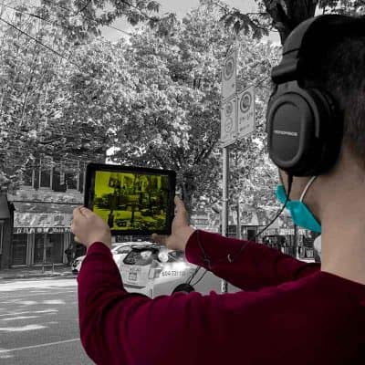 A man holding up a tablet to experience 360 Riot Walk in Chinatown