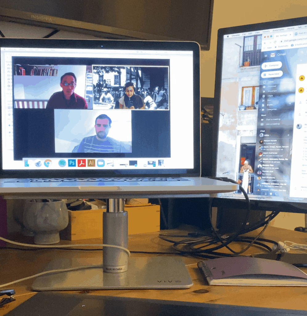 A laptop screen showing a virtual meeting between three people